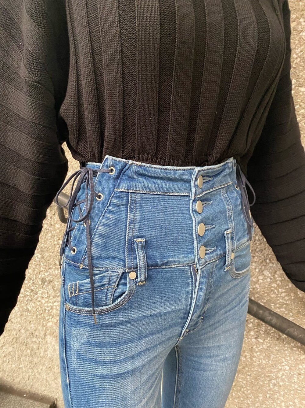 ブルー系のデニムパンツ、ブラック系のニット/セーター、ブラック系のブーツを着用したレディースの冬コーディネートの4枚目の写真