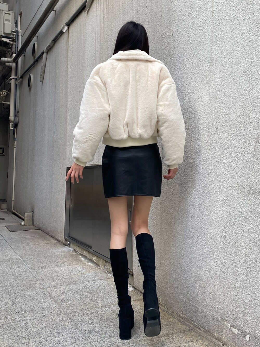 ブラック系のニット/セーター、ホワイト系のブルゾン、その他のスカートを着用したレディースの秋コーディネートの4枚目の写真
