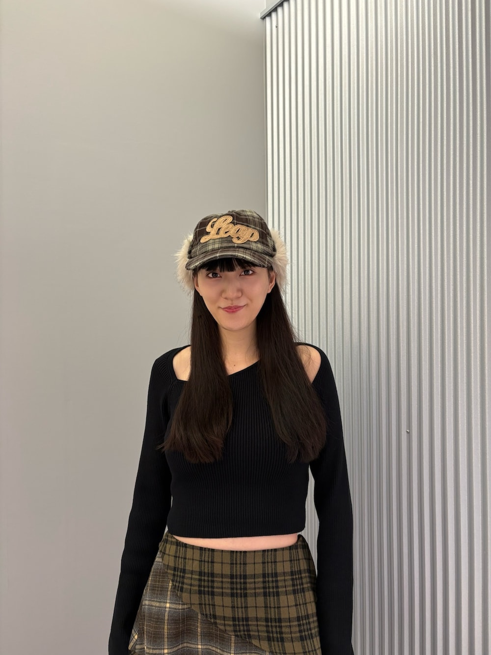 グリーン系のスカート、ブラック系のニット/セーター、ブラック系のブーツを着用したレディースの秋コーディネートの5枚目の写真