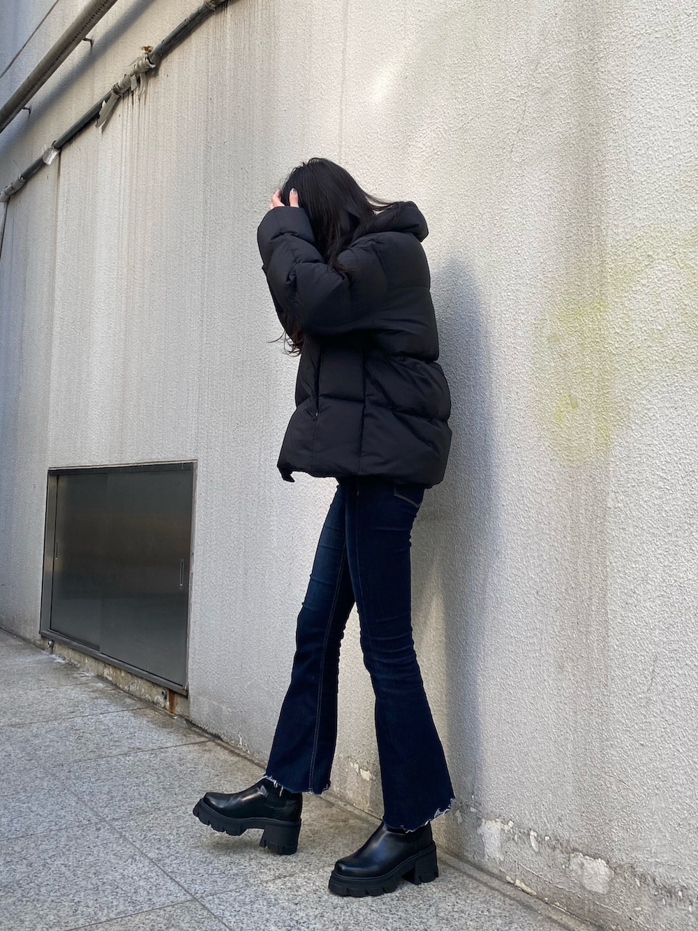 ブルー系のデニムパンツ、ホワイト系のニット/セーター、ブラック系のブーツを着用したレディースの冬コーディネートの4枚目の写真