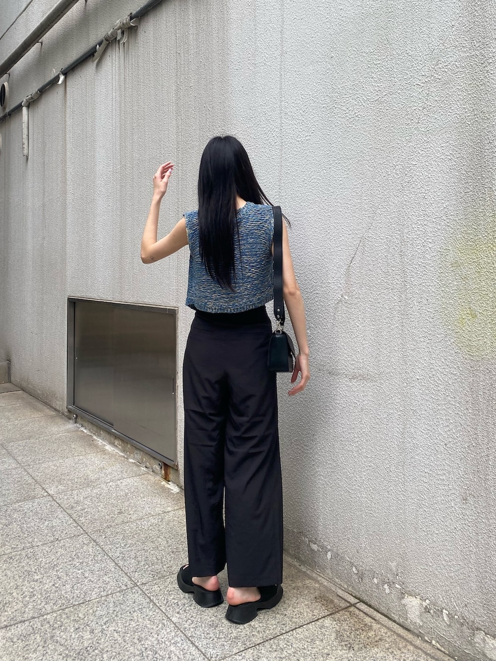 ホワイト系のニット/セーター、ブラック系のその他パンツ、ブラック系のショルダーバッグを着用したレディースの夏コーディネートの3枚目の写真