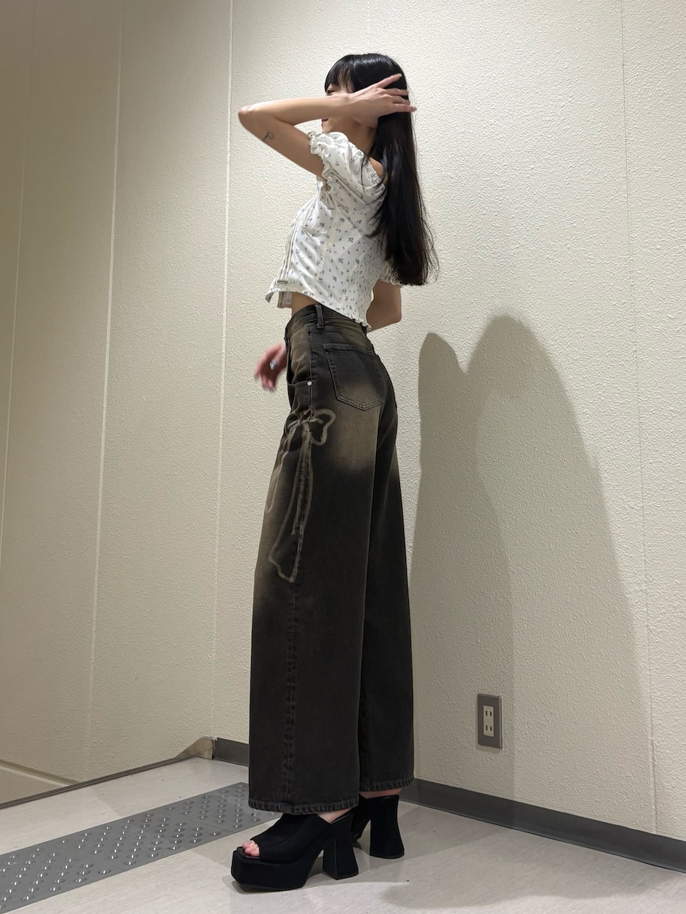 ブラック系のデニムパンツ、ブラック系のサンダルを着用したレディースの夏コーディネートの3枚目の写真