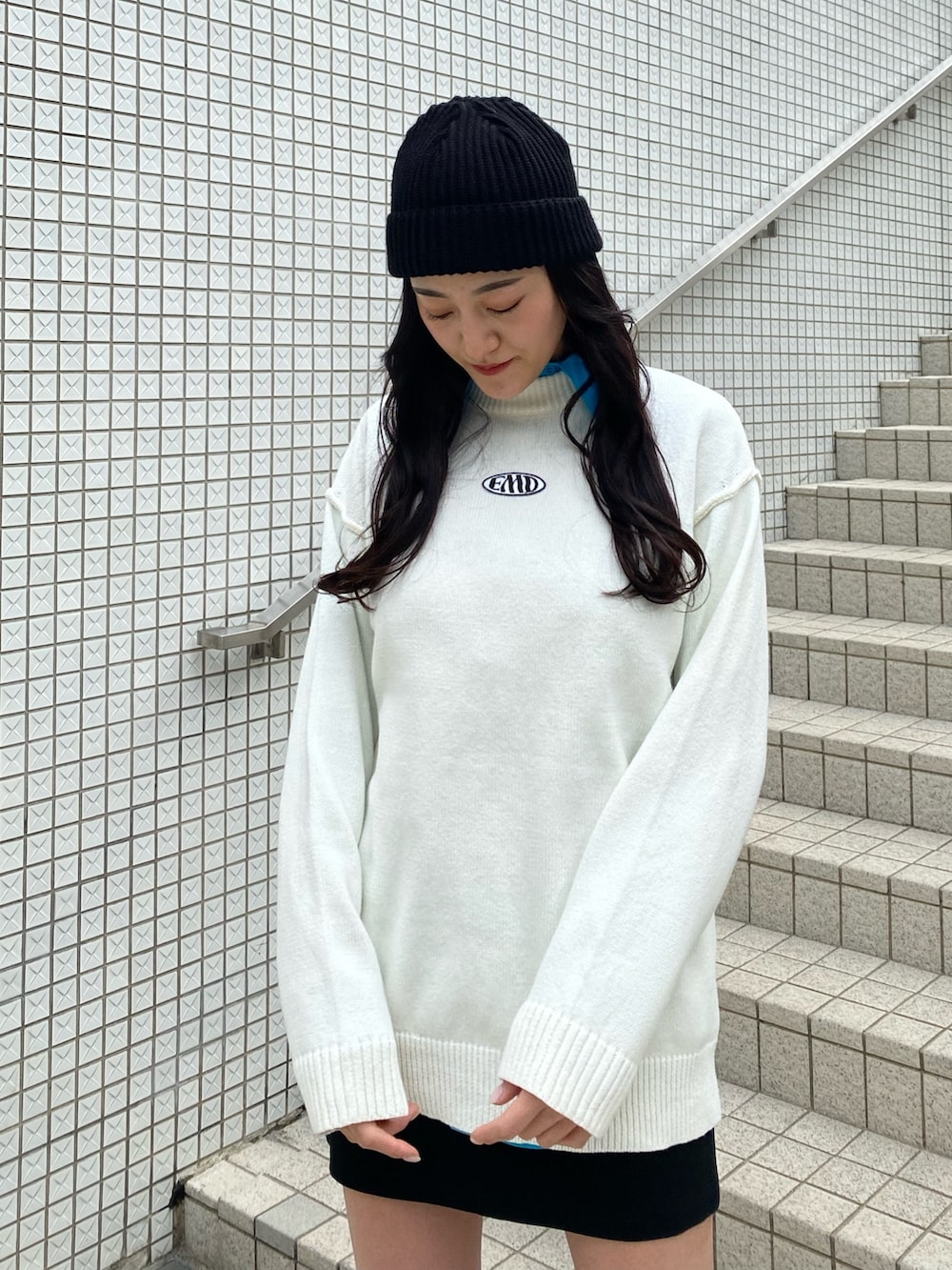 ブルー系のシャツ/ブラウス、ホワイト系のニット/セーター、ブラック系のスカートを着用したレディースの冬コーディネートの6枚目の写真