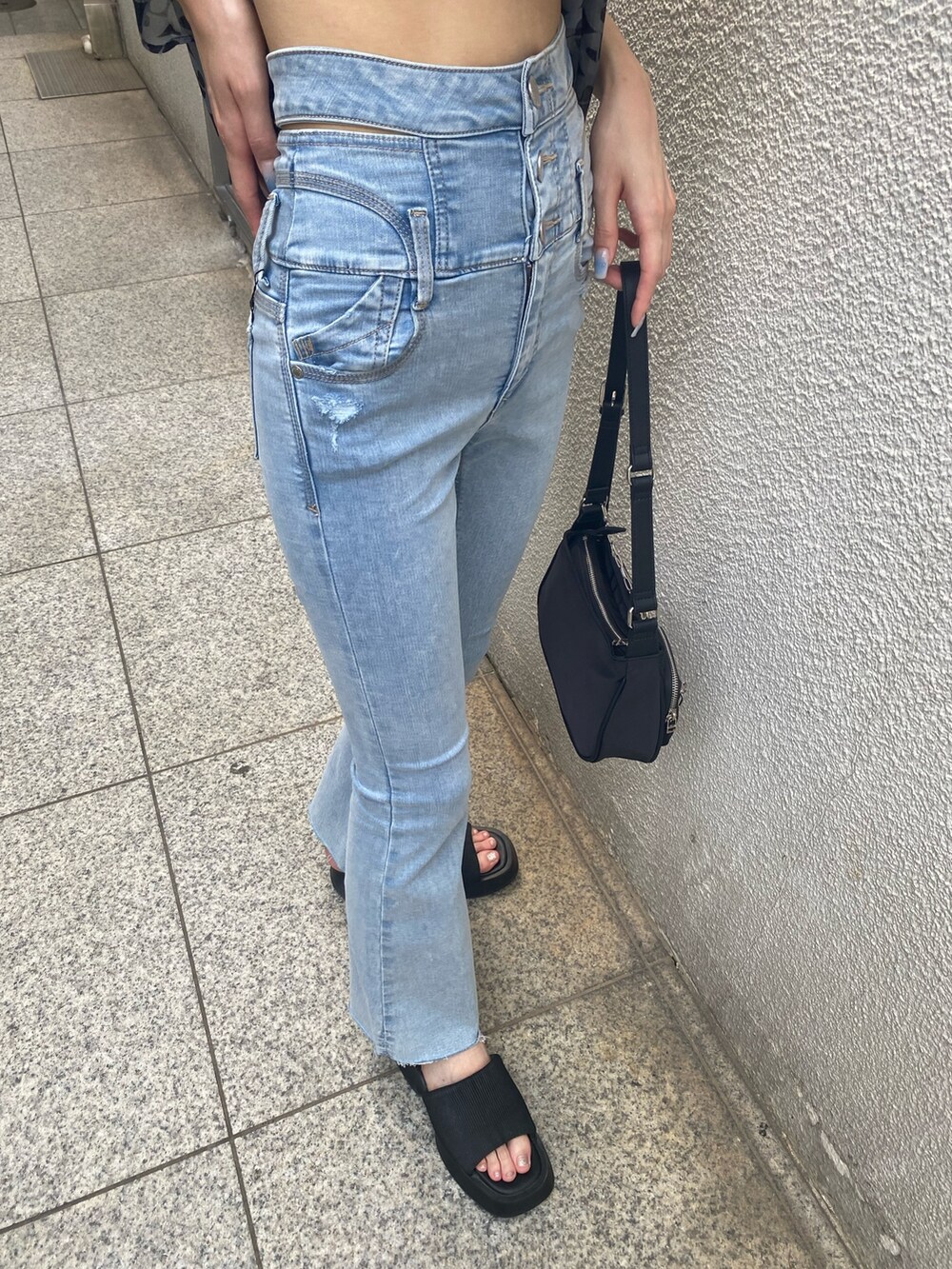 ブルー系のデニムパンツ、ブラック系のハンドバッグ、ブラック系のサンダルを着用したレディースの夏コーディネートの9枚目の写真