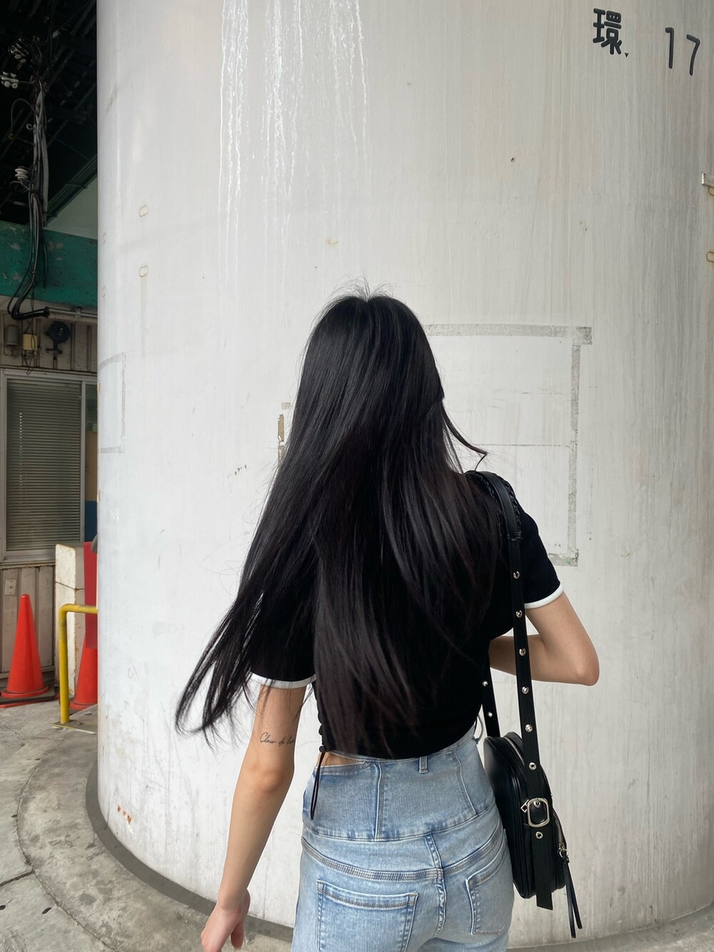 ブラック系のTシャツ/カットソー、ブルー系のデニムパンツ、ホワイト系のサンダルを着用したレディースの夏コーディネートの6枚目の写真