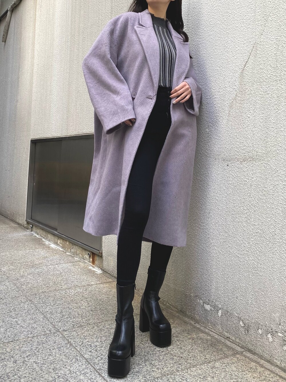 パープル系のチェスターコート、その他のニット/セーター、ブラック系のデニムパンツを着用したレディースの冬コーディネートの3枚目の写真