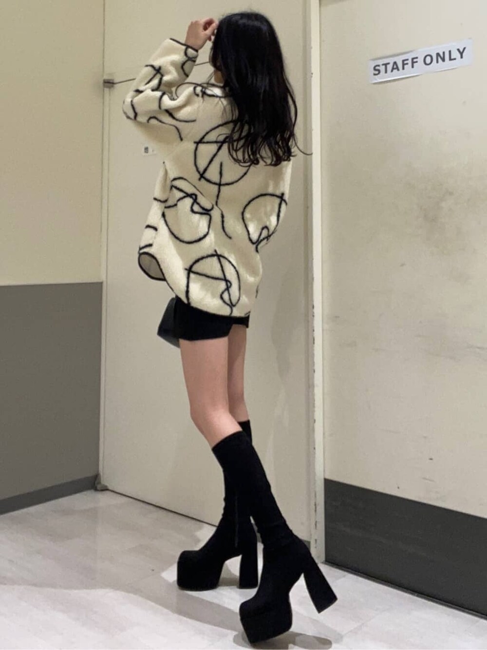 ブラック系のブーツ、ブラック系のスカート、その他のTシャツ/カットソーを着用したレディースの秋コーディネートの3枚目の写真