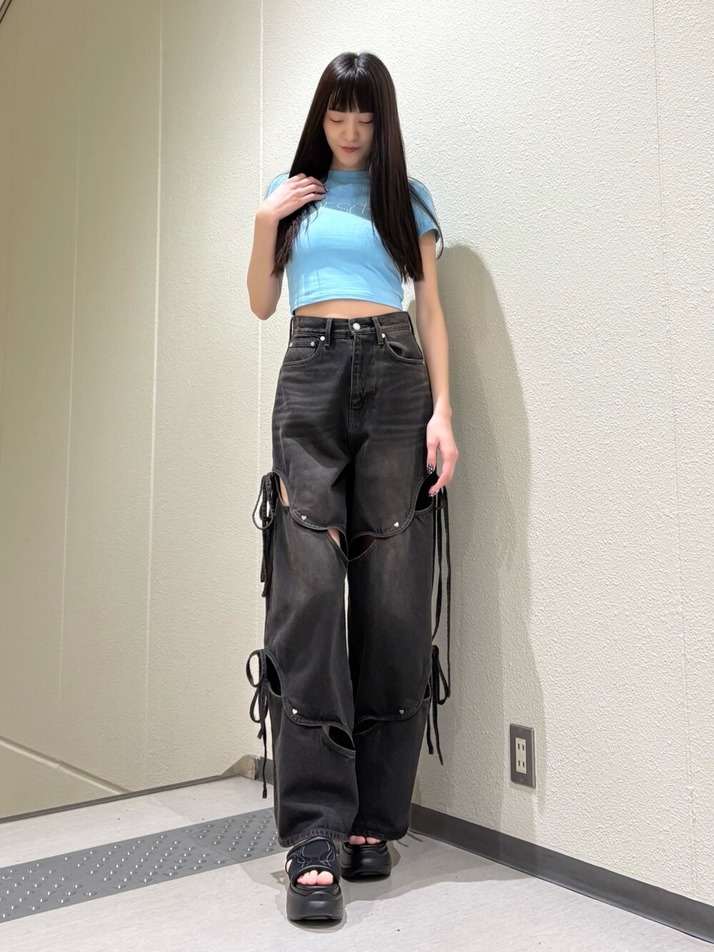 ブルー系のTシャツ/カットソー、ブラック系のデニムパンツ、ブラック系のサンダルを着用したレディースの春コーディネートの4枚目の写真