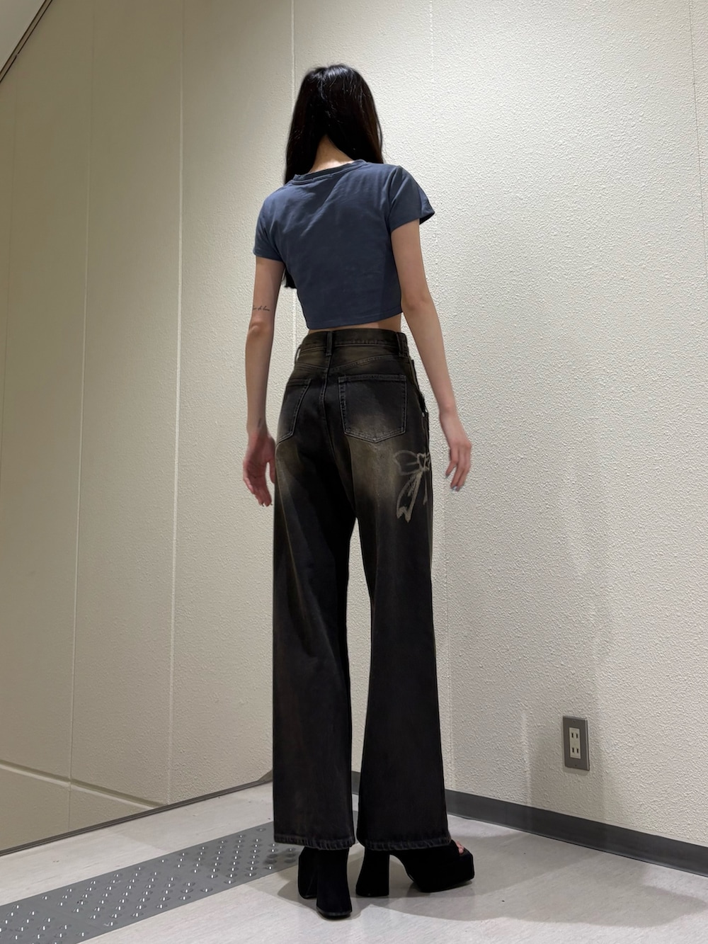 ブラック系のデニムパンツ、ブルー系のTシャツ/カットソー、ブラック系のサンダルを着用したレディースの夏コーディネートの3枚目の写真