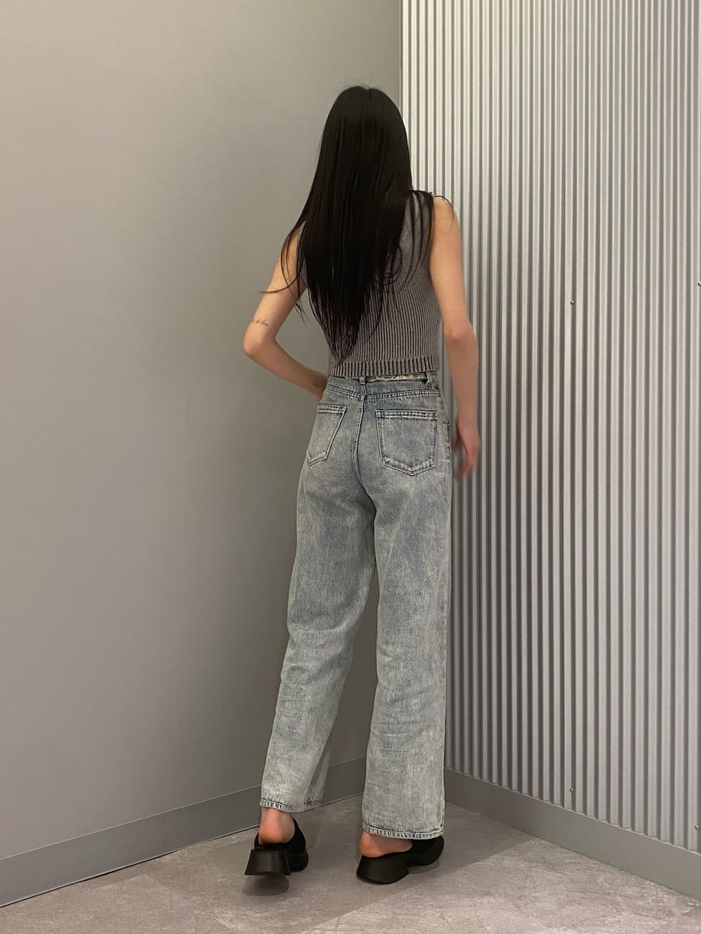 ブルー系のデニムパンツ、グレー系のニット/セーター、ブラック系のサンダルを着用したレディースの春コーディネートの3枚目の写真