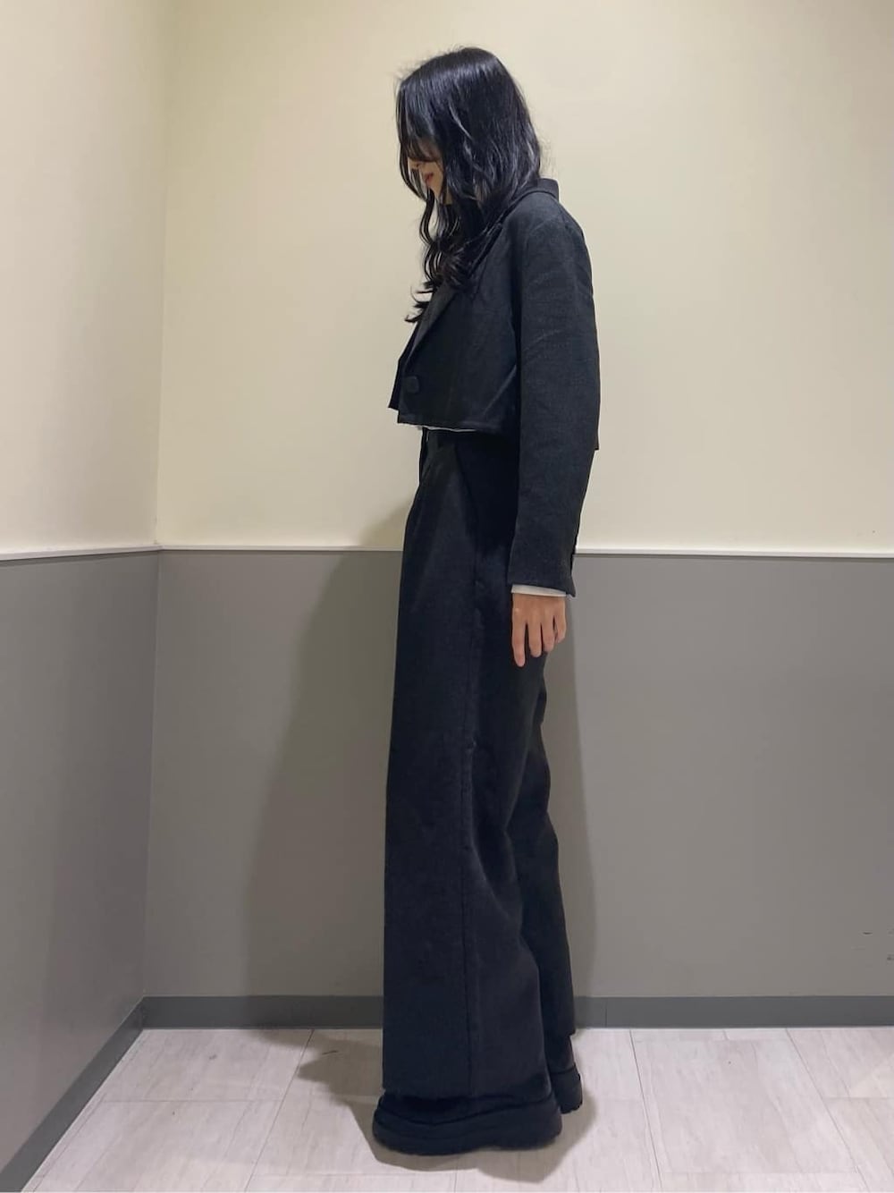 グレー系のテーラードジャケット、グレー系のその他パンツ、ブラック系のハンドバッグを着用したレディースの秋コーディネートの4枚目の写真