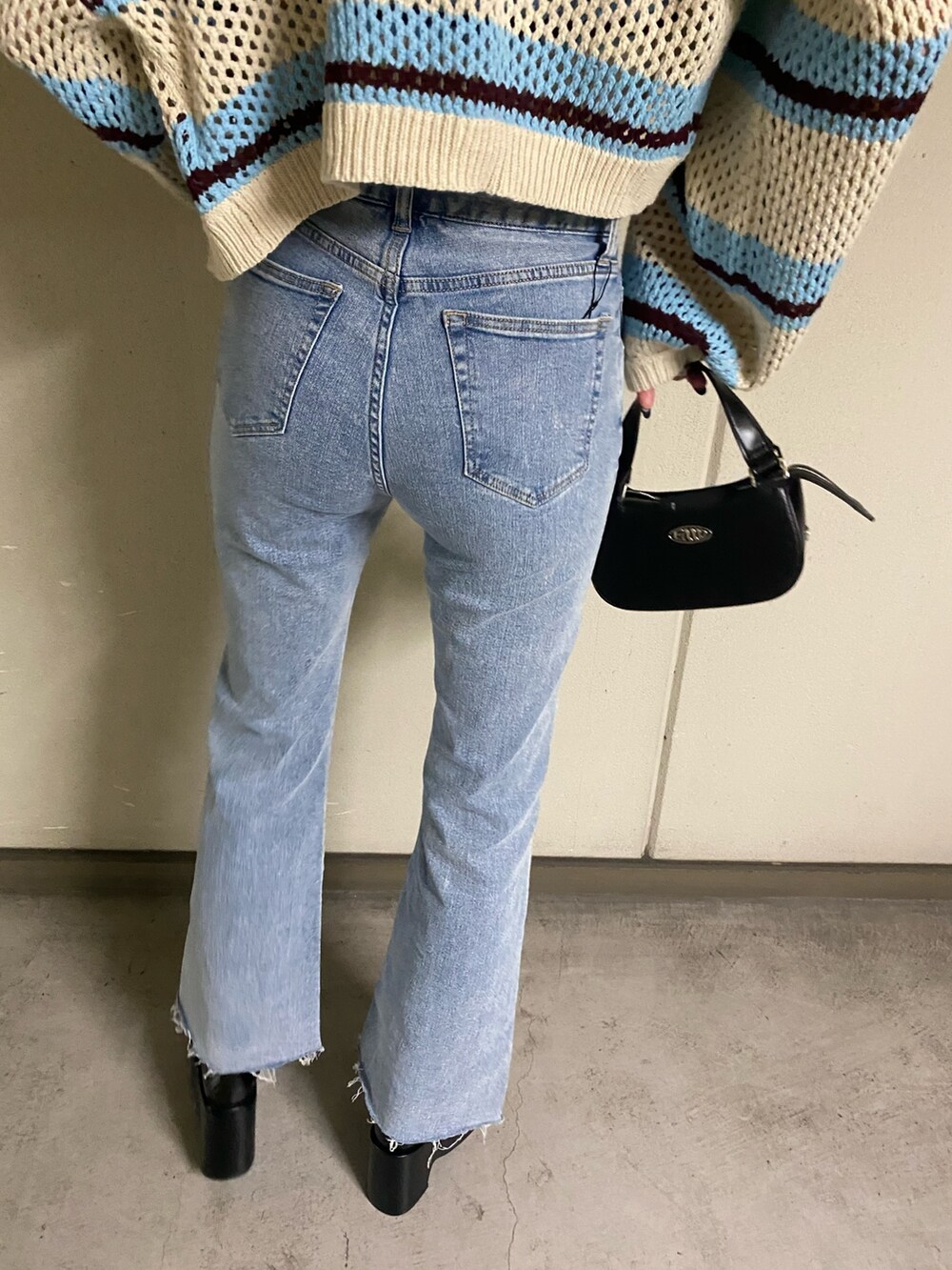 その他のニット/セーター、ブルー系のデニムパンツ、ブラック系のハンドバッグを着用したレディースの春コーディネートの9枚目の写真