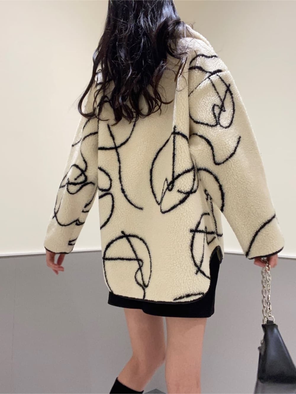 ブラック系のブーツ、ブラック系のスカート、その他のTシャツ/カットソーを着用したレディースの秋コーディネートの6枚目の写真