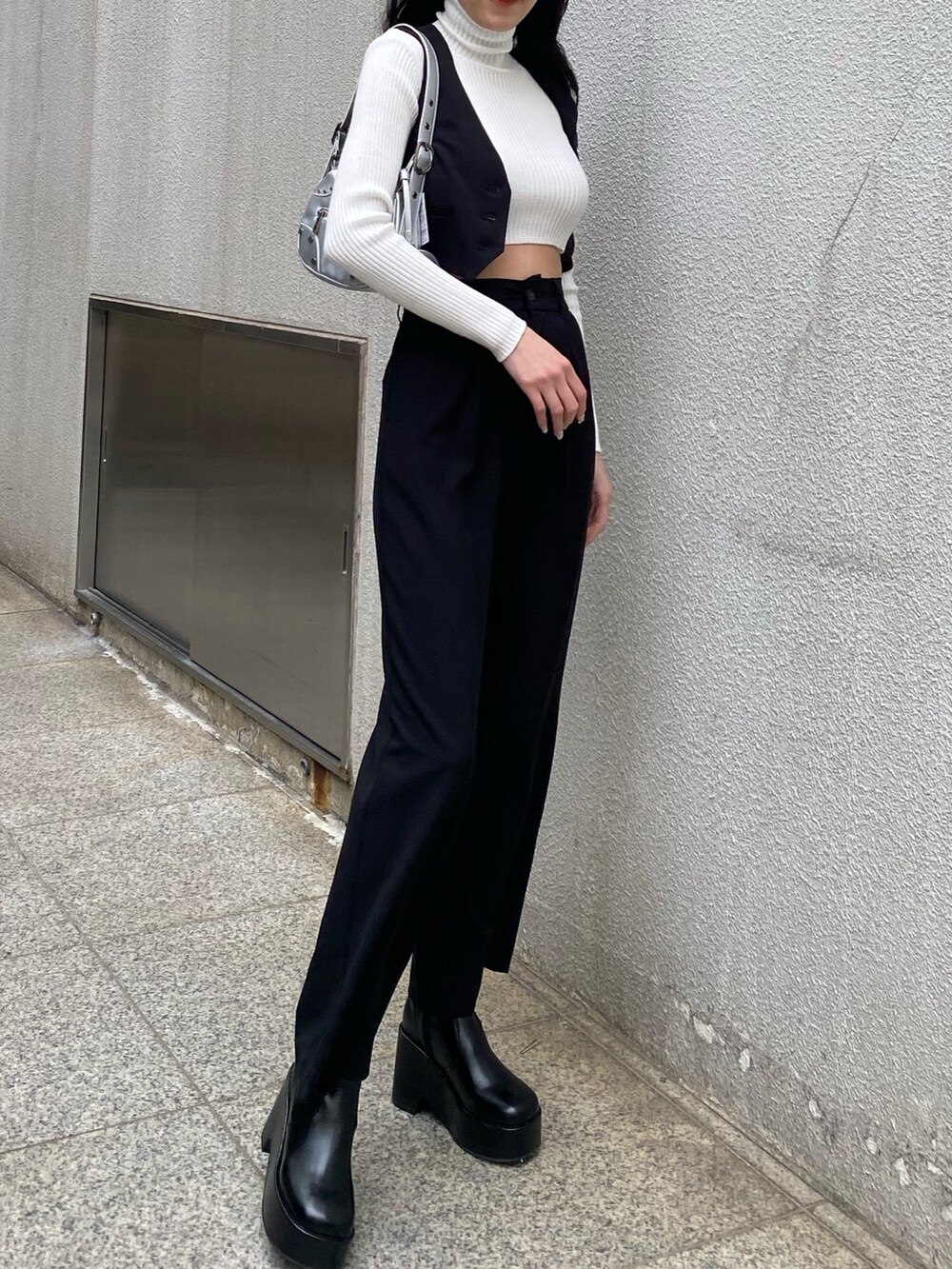 ブラック系のベスト、ブラック系のその他パンツ、ホワイト系のニット/セーターを着用したレディースの春コーディネートの4枚目の写真