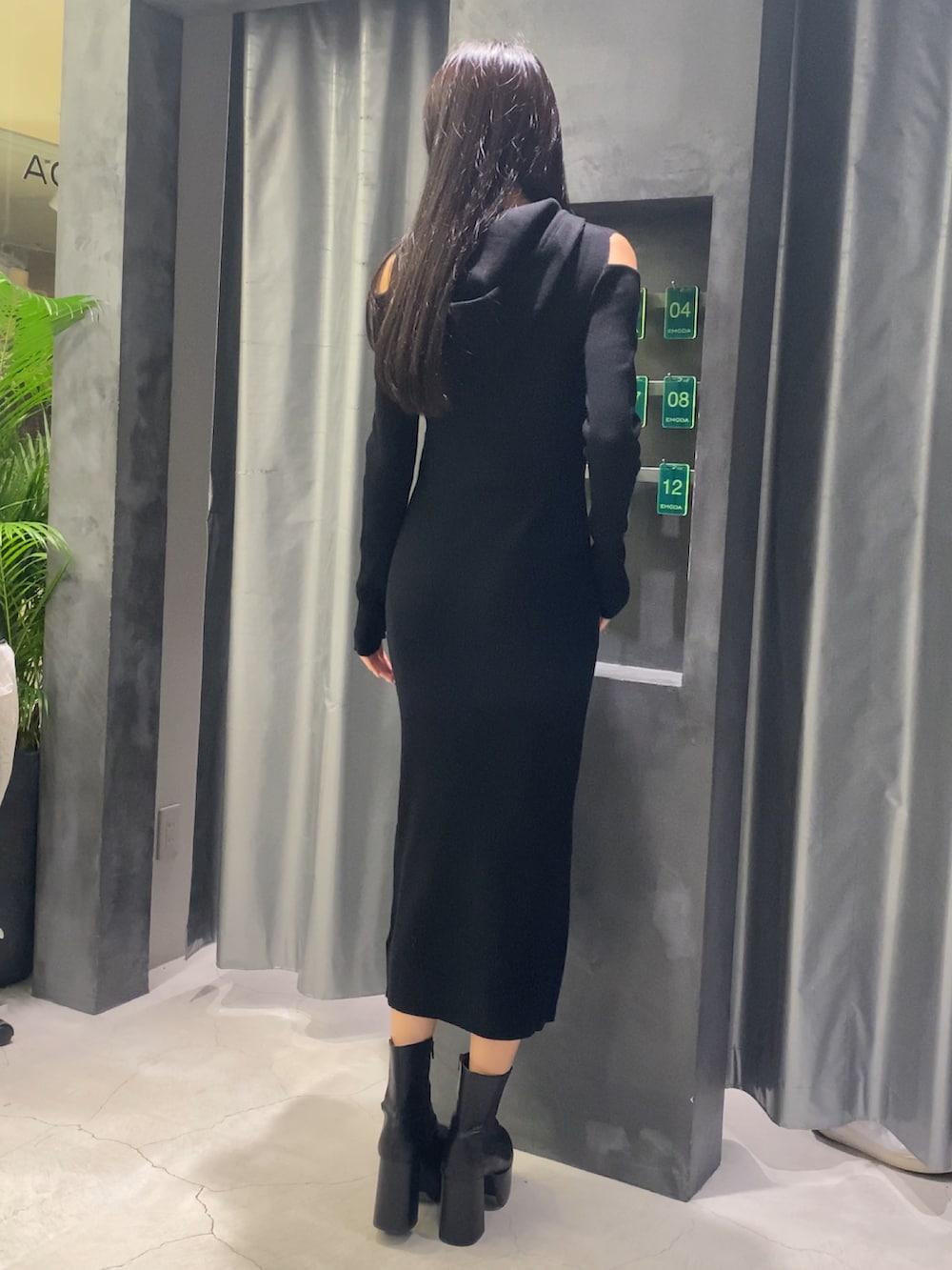 ブラック系のワンピース、ブラック系のブーツを着用したレディースの秋コーディネートの6枚目の写真