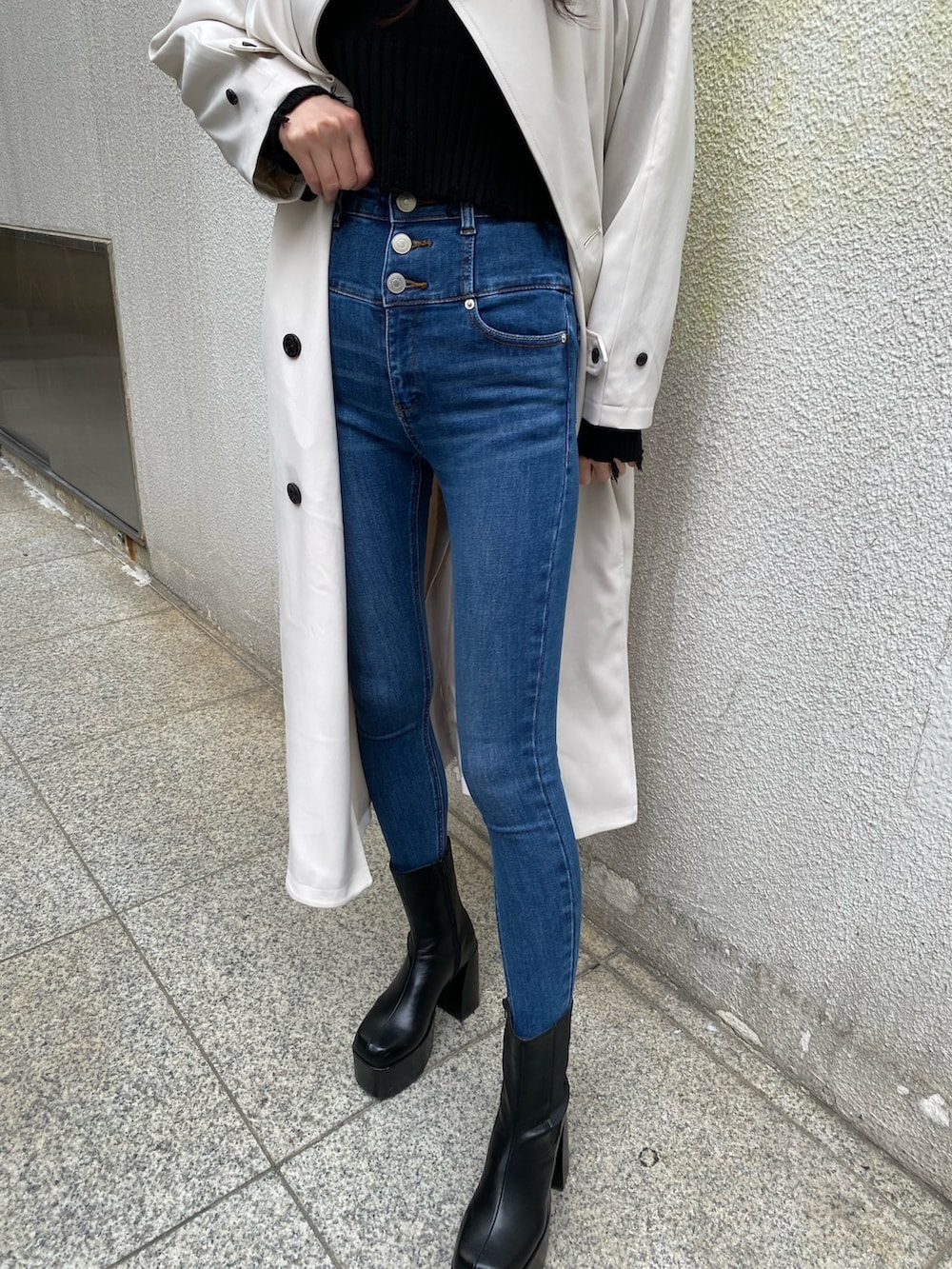 ブラック系のニット/セーター、ブルー系のデニムパンツ、ブラック系のブーツを着用したレディースの冬コーディネートの8枚目の写真