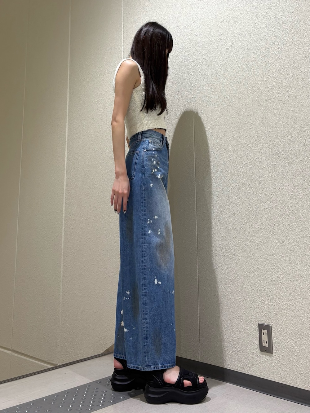 ブルー系のデニムパンツ、ホワイト系のニット/セーター、ブラック系のサンダルを着用したレディースの夏コーディネートの4枚目の写真