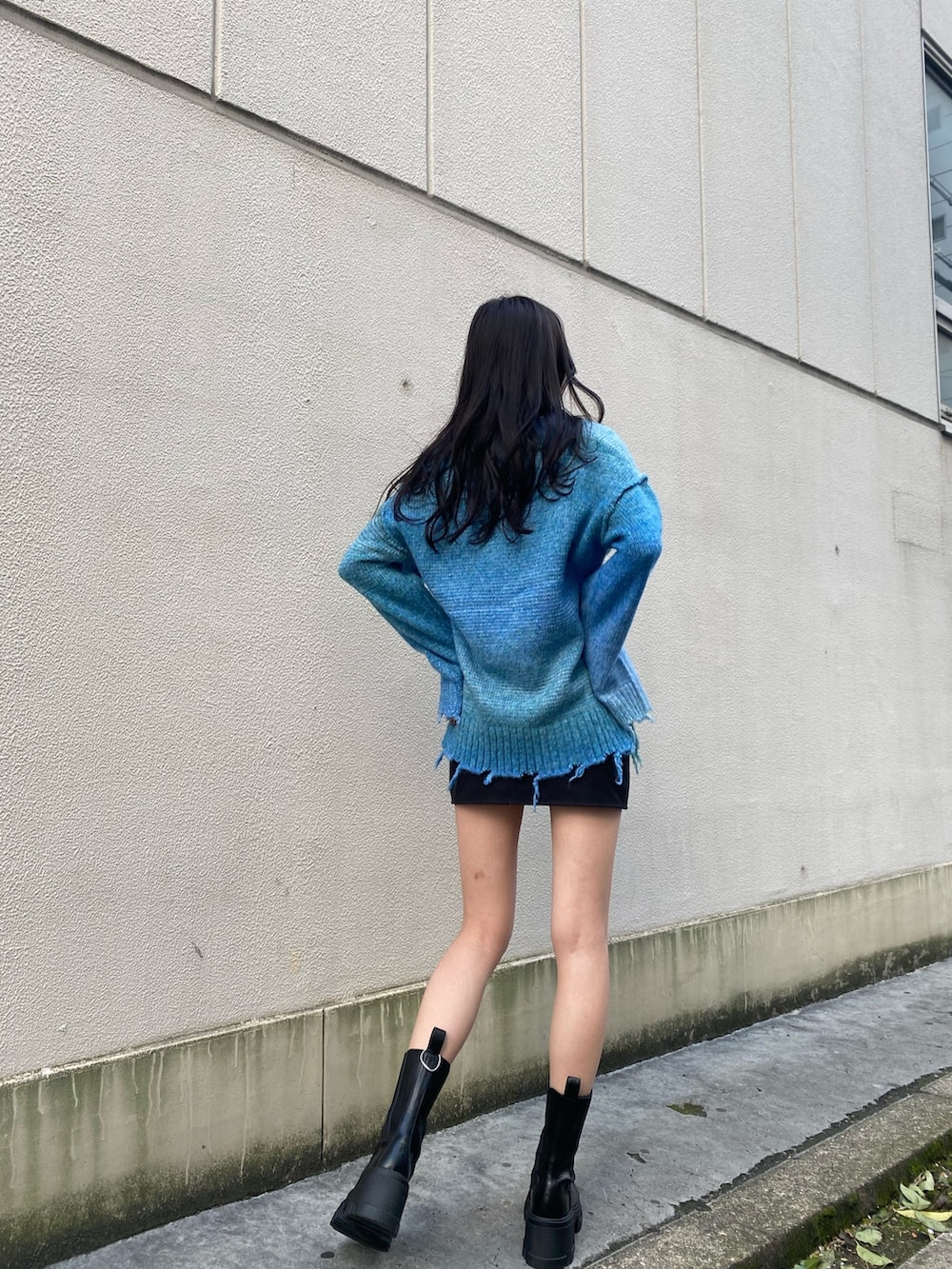 ブルー系のニット/セーター、ブラック系のブーツ、ホワイト系のダウンジャケット/コートを着用したレディースの冬コーディネートの6枚目の写真