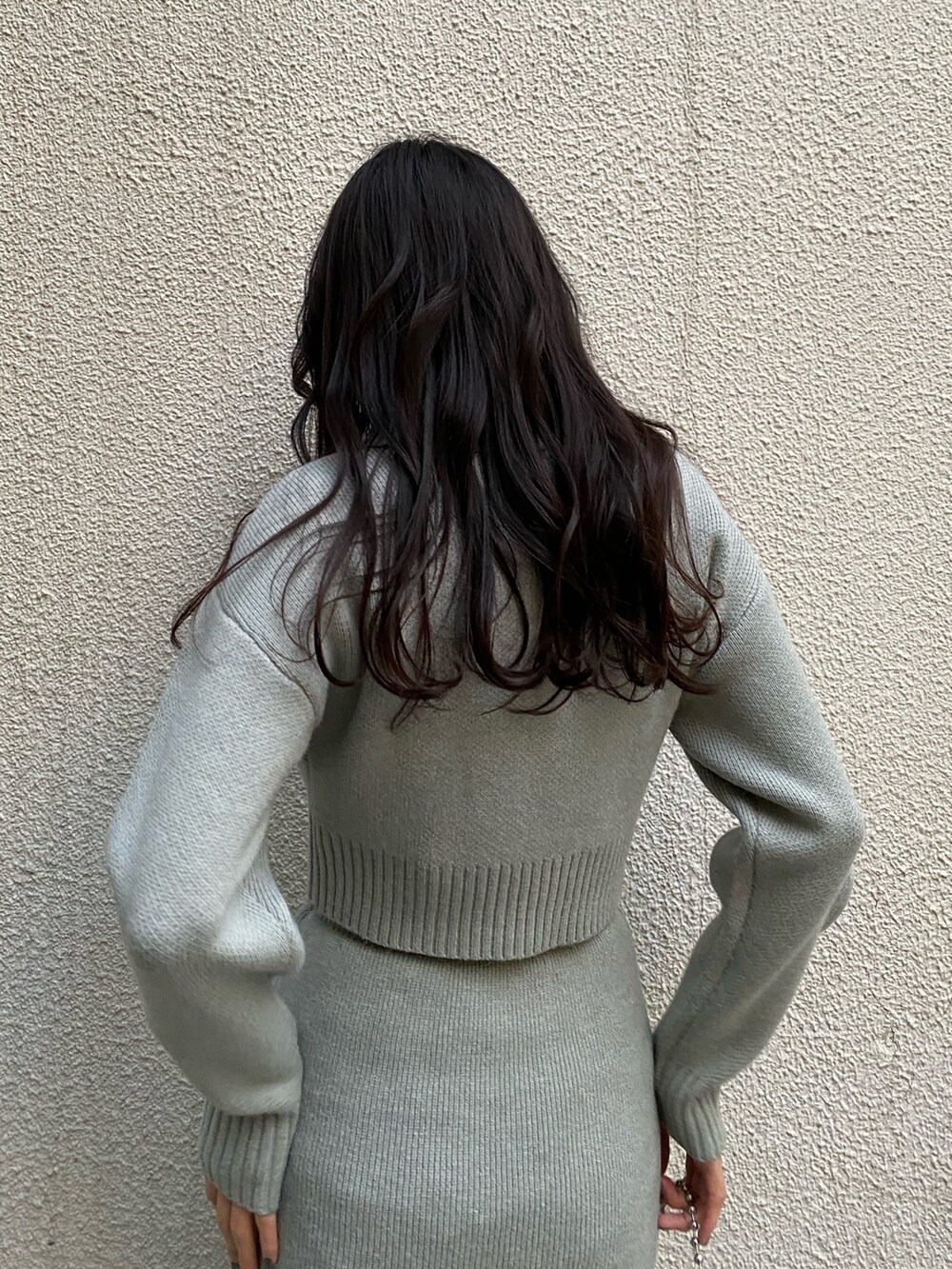 ブラック系のハンドバッグ、グレー系のスカート、グレー系のニット/セーターを着用したレディースの冬コーディネートの5枚目の写真