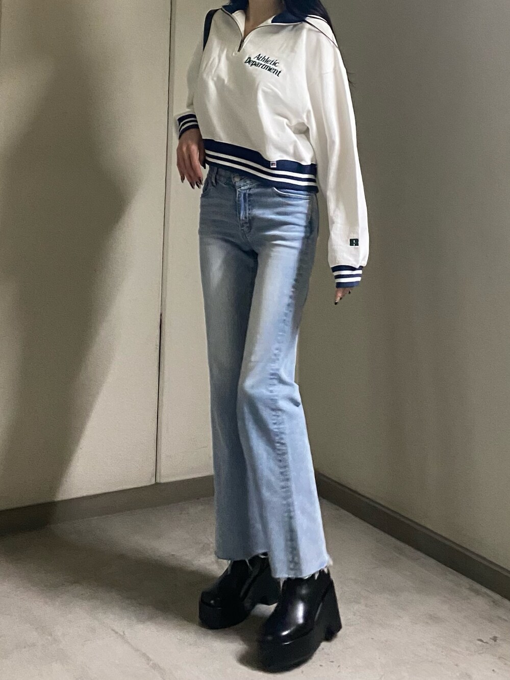 ホワイト系のTシャツ/カットソー、ブルー系のデニムパンツ、ブラック系のブーツを着用したレディースの春コーディネートの5枚目の写真