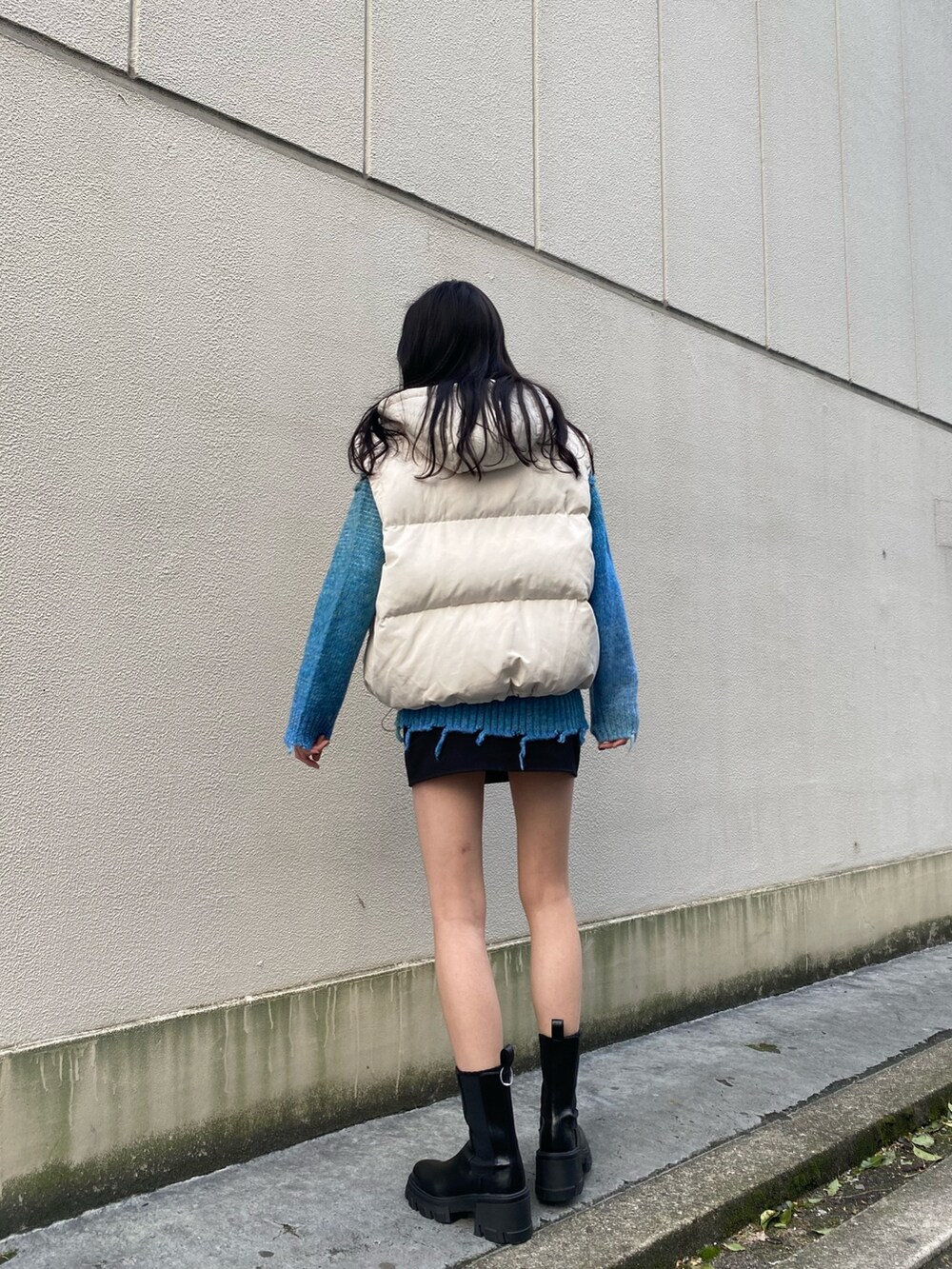 ブルー系のニット/セーター、ブラック系のブーツ、ホワイト系のダウンジャケット/コートを着用したレディースの冬コーディネートの3枚目の写真