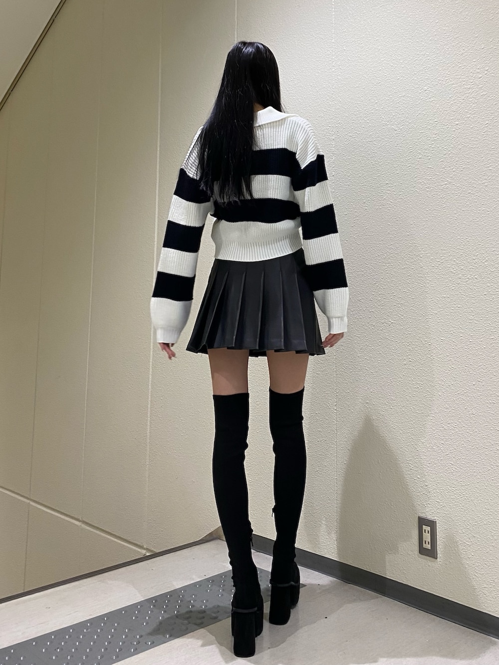 ブラック系のスカート、その他のニット/セーター、ブラック系のブーツを着用したレディースの冬コーディネートの4枚目の写真