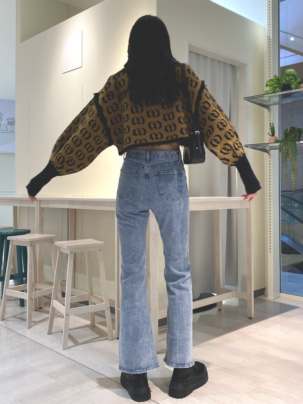 ブルー系のデニムパンツ、その他のニット/セーター、ブラック系のショルダーバッグを着用したレディースの秋コーディネートの4枚目の写真