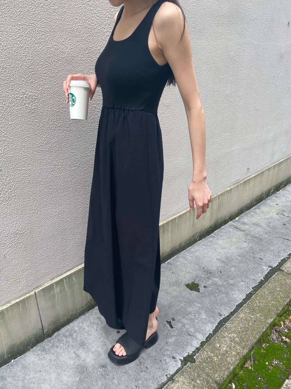 ブラック系のワンピース、ブラック系のサンダル、ホワイト系のハットを着用したレディースの夏コーディネートの6枚目の写真