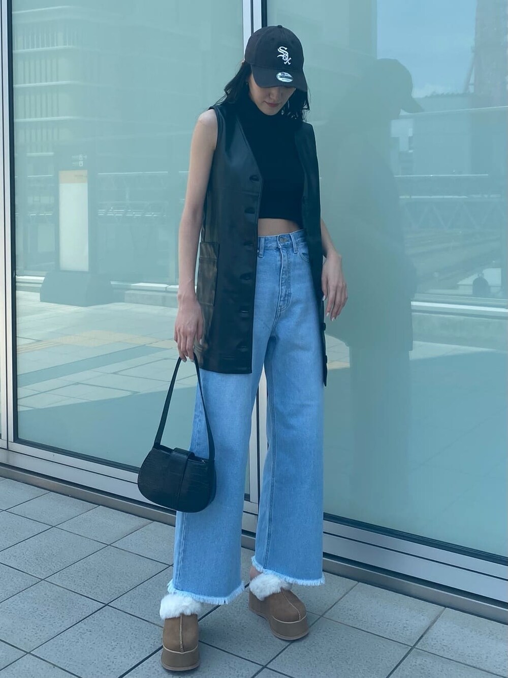 ブルー系のデニムパンツ、ブラック系のワンピース、ベージュ系のスリッポンを着用したレディースの夏コーディネートの2枚目の写真