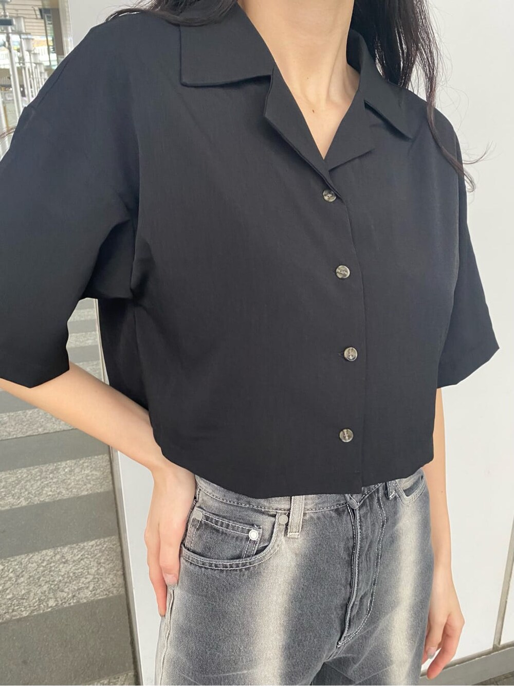 ブラック系のデニムパンツ、ブラック系のシャツ/ブラウス、ホワイト系のスニーカーを着用したレディースの春コーディネートの4枚目の写真