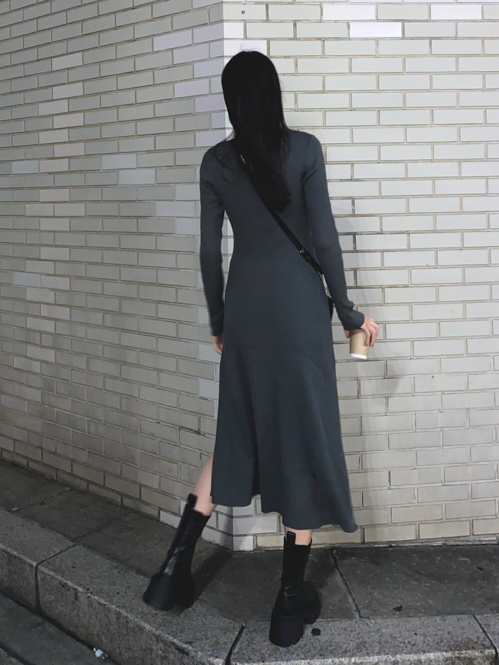 グレー系のワンピース、ブラック系のブーツを着用したレディースの秋コーディネートの3枚目の写真