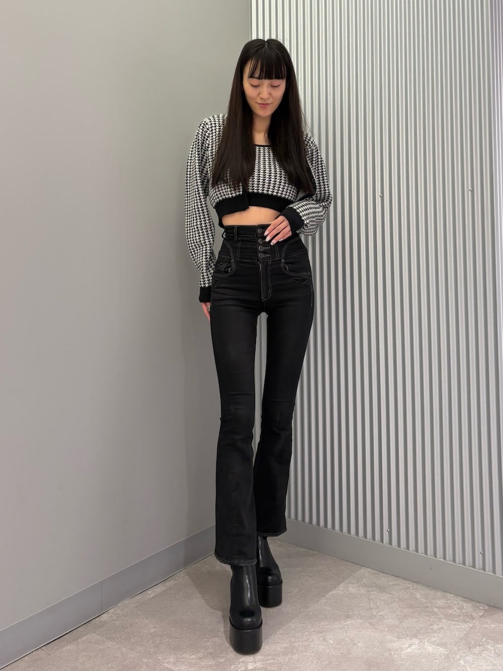 ブラック系のデニムパンツ、ブラック系のニット/セーター、ブラック系のブーツを着用したレディースの秋コーディネートの5枚目の写真