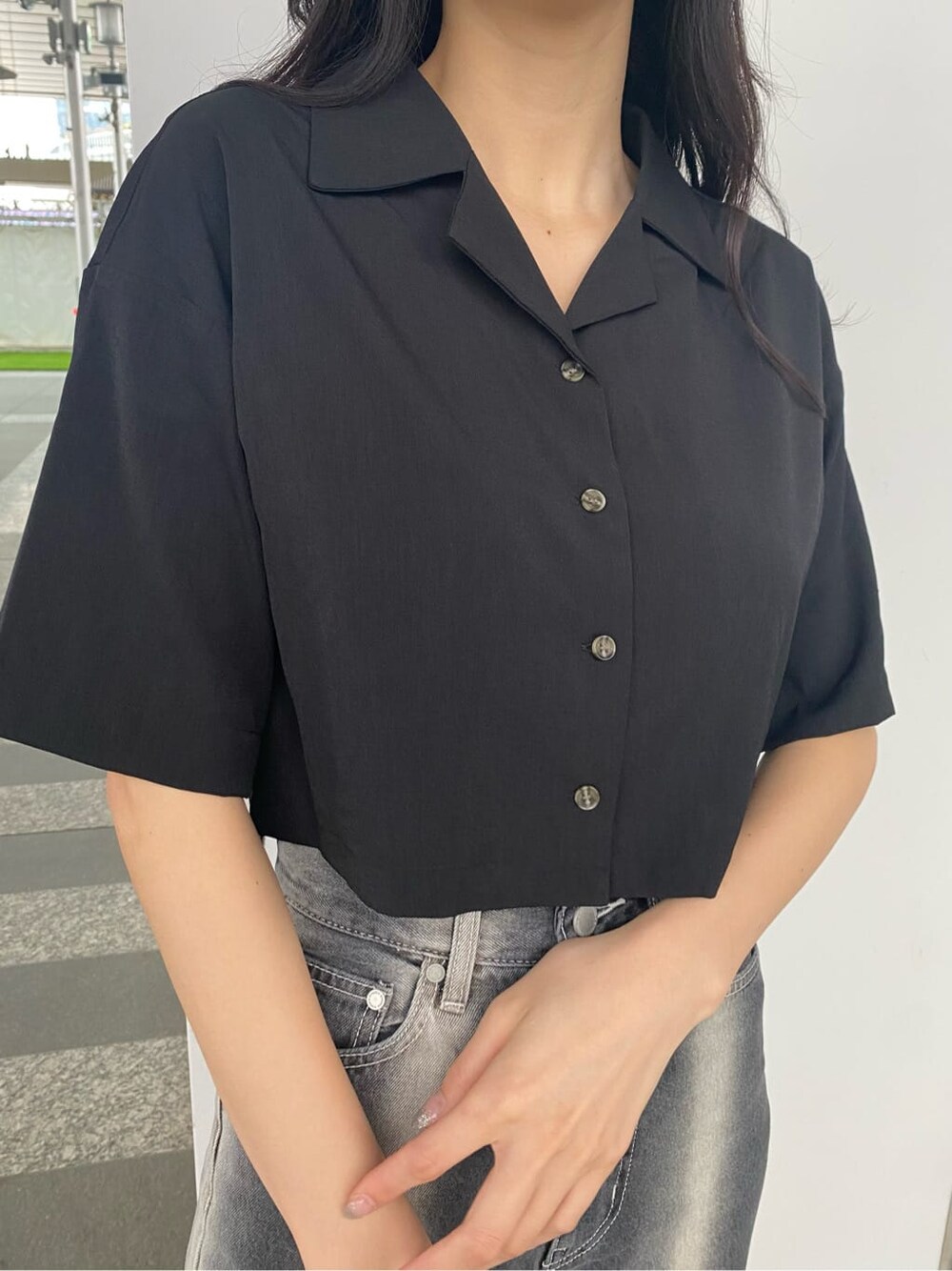 ブラック系のデニムパンツ、ブラック系のシャツ/ブラウス、ホワイト系のスニーカーを着用したレディースの春コーディネートの5枚目の写真