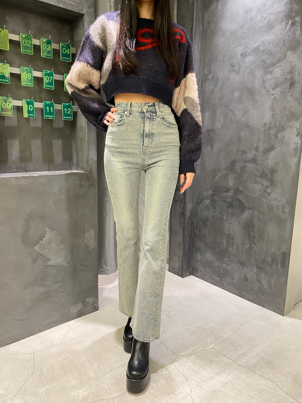 ブルー系のデニムパンツ、ブルー系のニット/セーター、ブラック系のブーツを着用したレディースの秋コーディネートの8枚目の写真