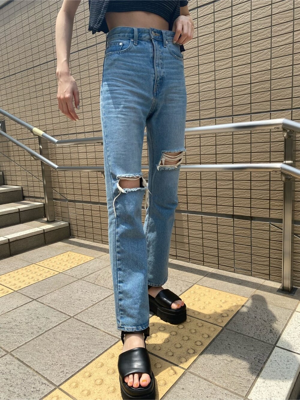 ブラック系のサンダル、ブルー系のデニムパンツ、その他のアンサンブルを着用したレディースの夏コーディネートの3枚目の写真