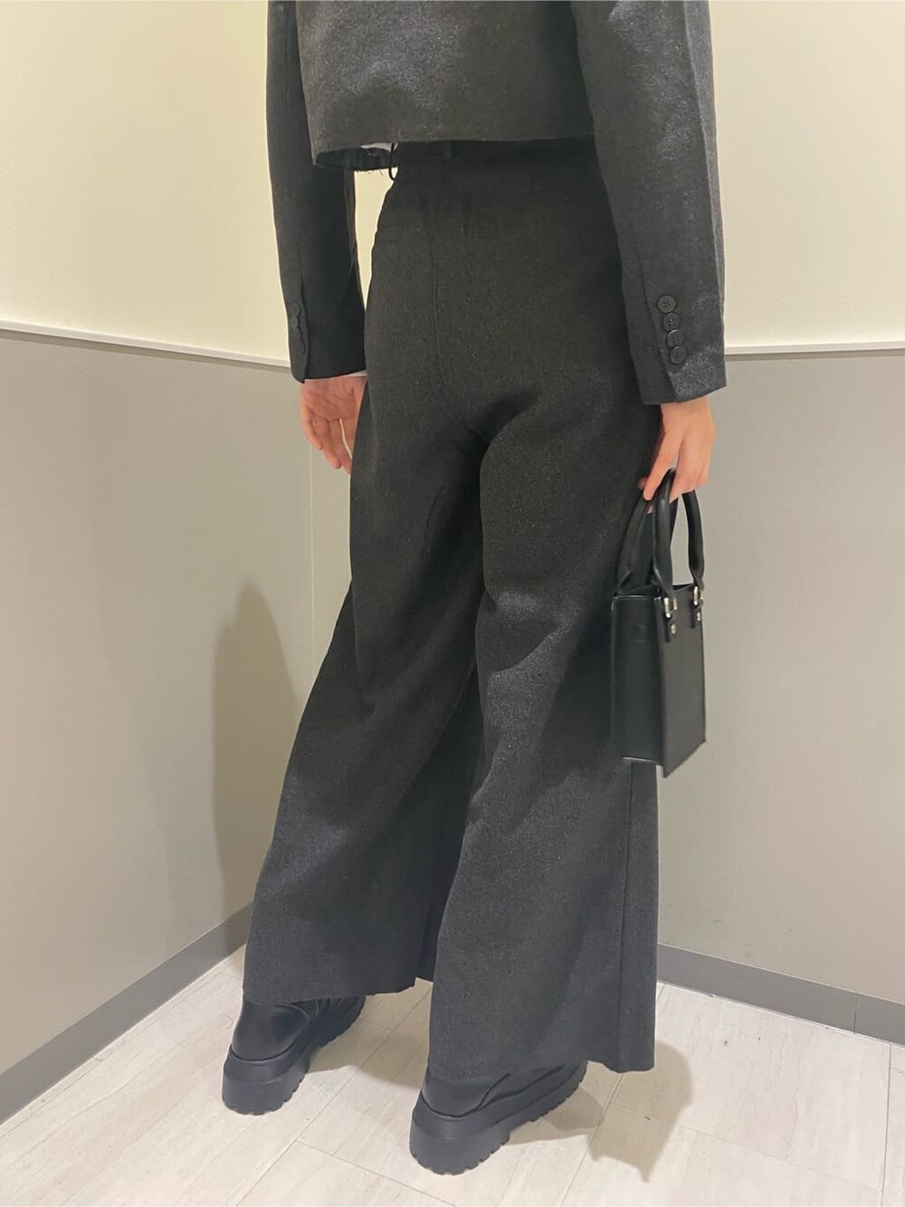 グレー系のテーラードジャケット、グレー系のその他パンツ、ブラック系のハンドバッグを着用したレディースの秋コーディネートの6枚目の写真