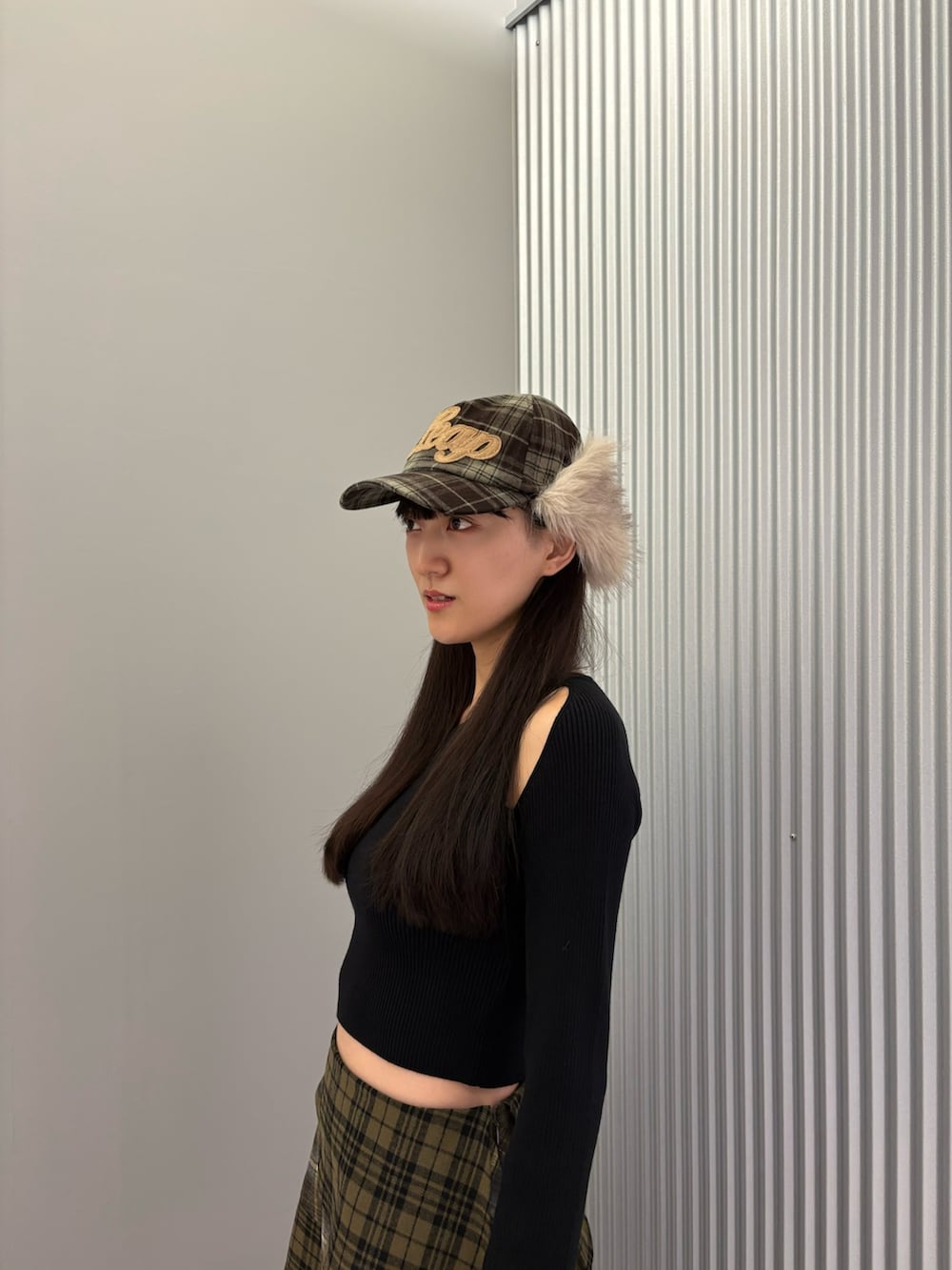 ブルー系のデニムパンツ、ブラック系のニット/セーター、ブラック系のスニーカーを着用したレディースの秋コーディネートの6枚目の写真