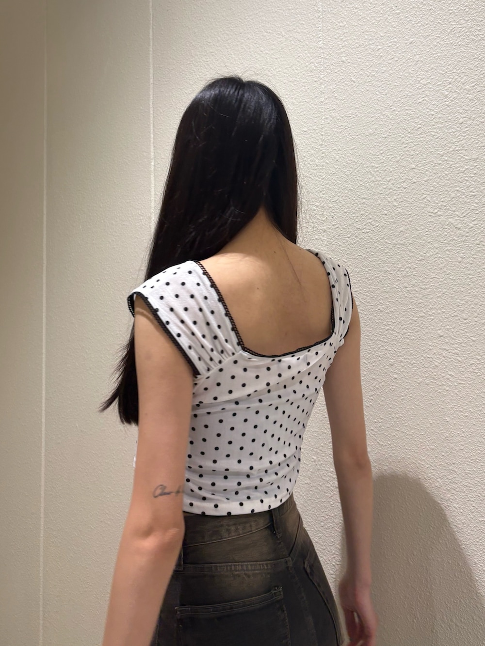 ブラック系のデニムパンツ、ホワイト系のタンクトップ、ブラック系のTシャツ/カットソーを着用したレディースの夏コーディネートの7枚目の写真
