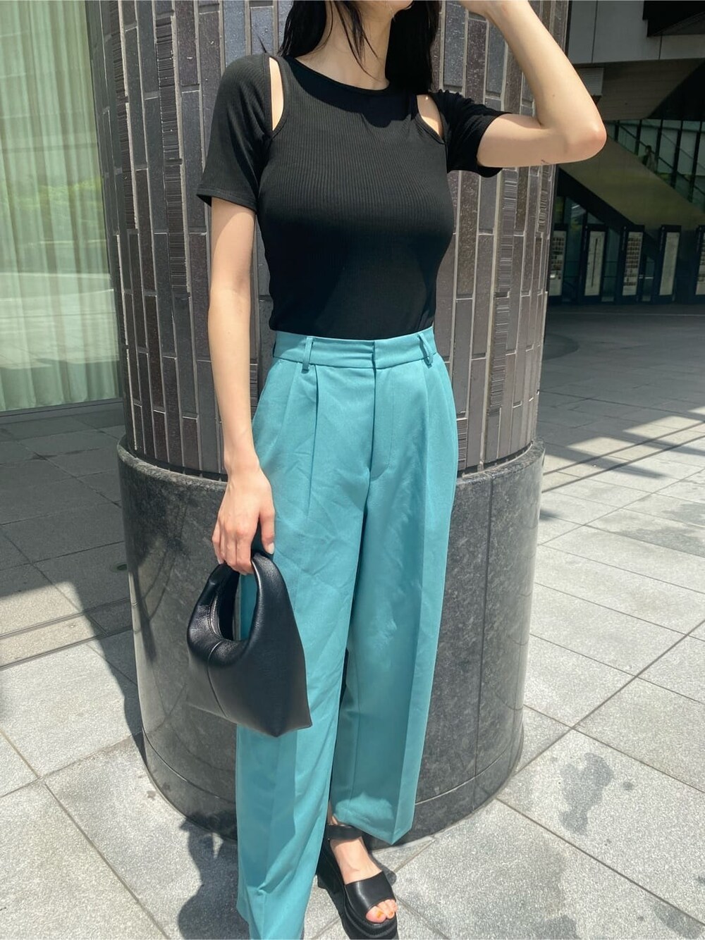 ブルー系のその他パンツ、ブラック系のサンダル、ブラック系のハンドバッグを着用したレディースの夏コーディネートの2枚目の写真