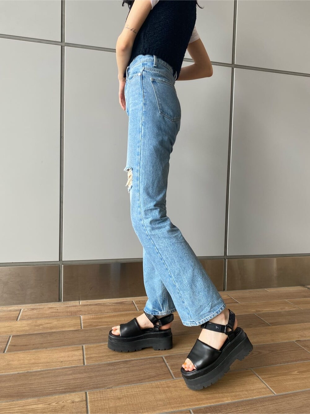 ブラック系のベスト、ブルー系のデニムパンツ、ホワイト系のTシャツ/カットソーを着用したレディースの夏コーディネートの4枚目の写真