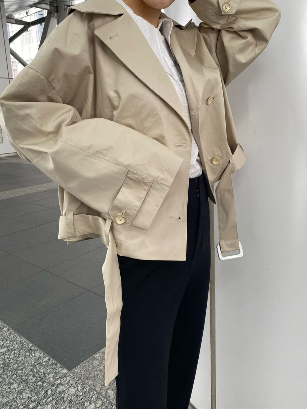 ブラック系のその他パンツ、ベージュ系のトレンチコート、ブラック系のブーツを着用したレディースの冬コーディネートの5枚目の写真