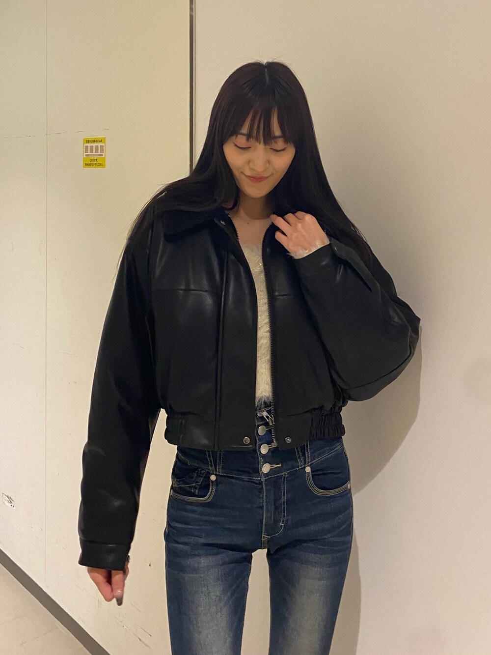 ブルー系のデニムパンツ、ホワイト系のニット/セーター、ブラック系のブルゾンを着用したレディースの秋コーディネートの7枚目の写真