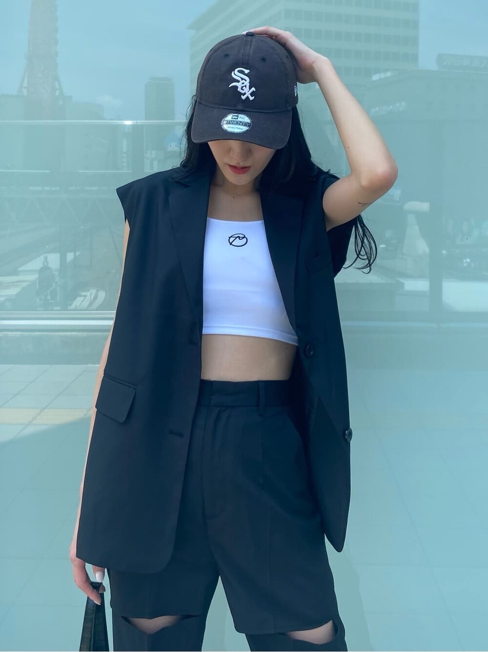 ホワイト系のスニーカー、ブラック系のベスト、ブラック系のその他パンツを着用したレディースの夏コーディネートの6枚目の写真