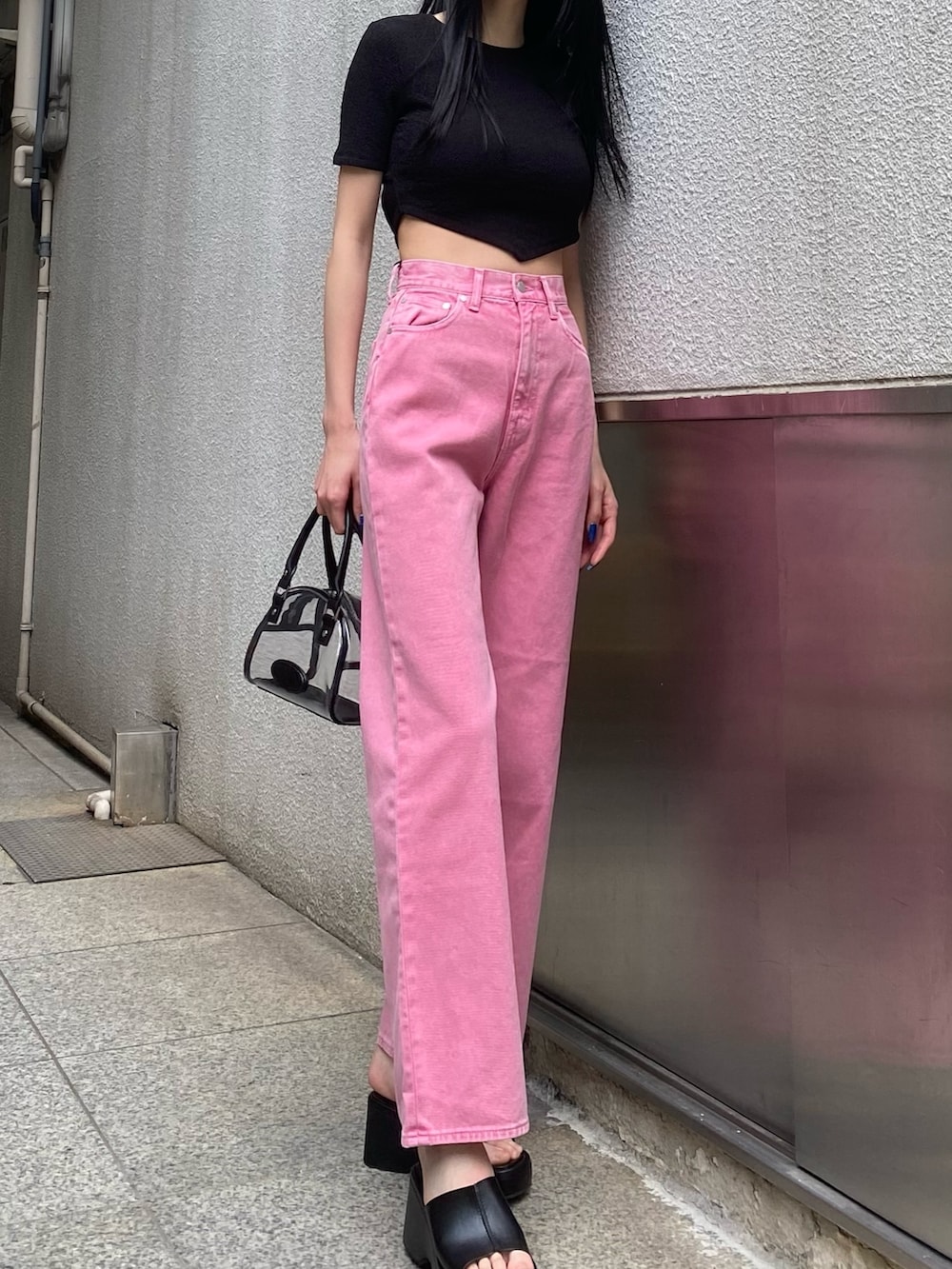ピンク系のデニムパンツ、ブラック系のTシャツ/カットソー、その他のハンドバッグを着用したレディースの春コーディネートの4枚目の写真
