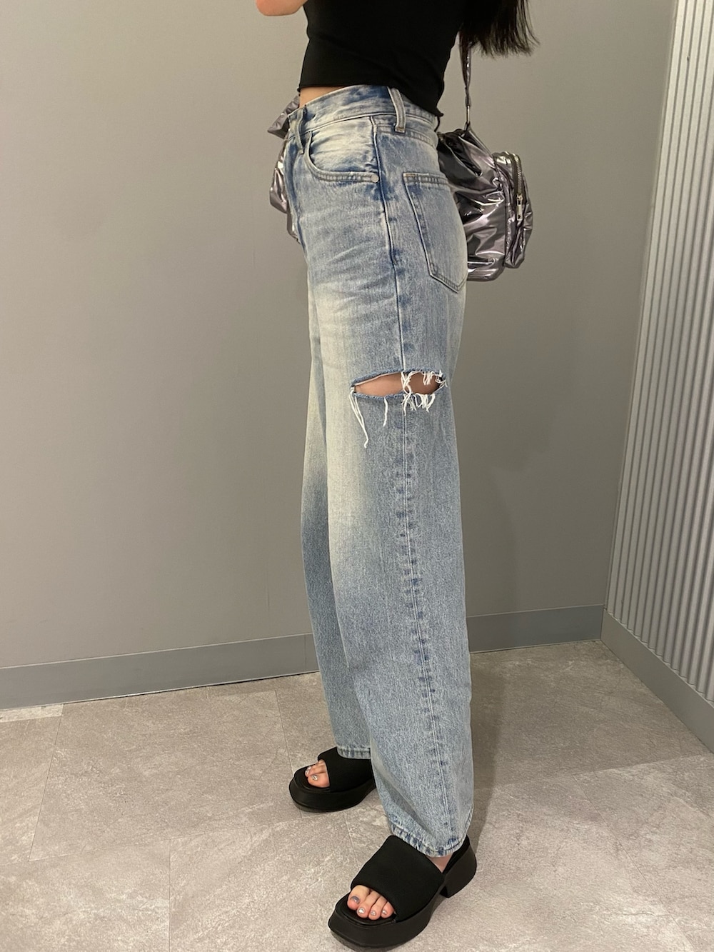 ブラック系のTシャツ/カットソー、ブラック系のサンダル、ブルー系のデニムパンツを着用したレディースの夏コーディネートの9枚目の写真