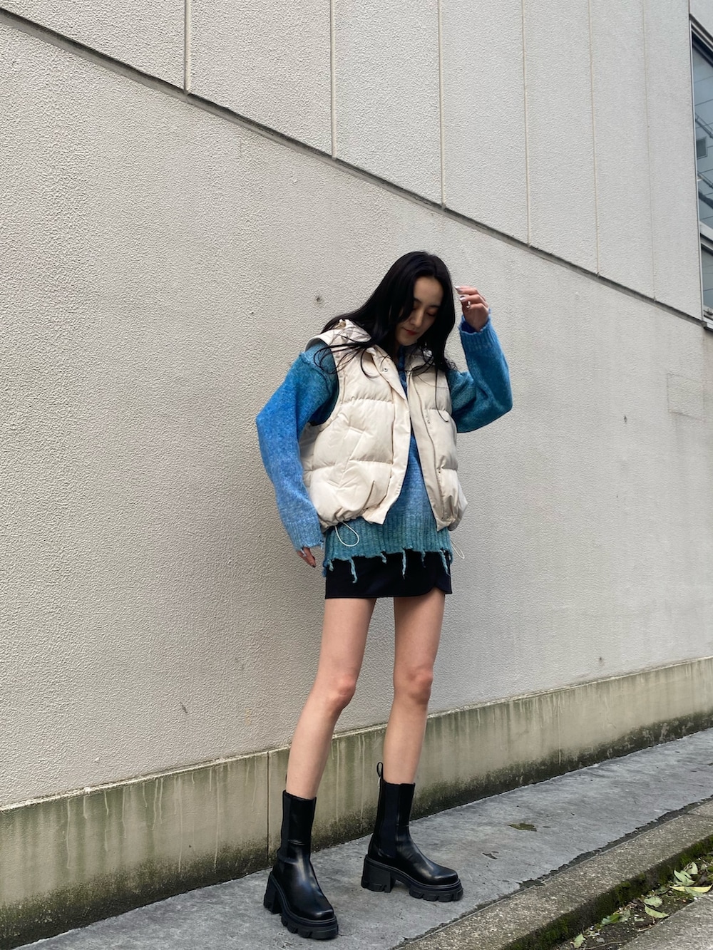 ブルー系のニット/セーター、ブラック系のブーツ、ホワイト系のダウンジャケット/コートを着用したレディースの冬コーディネートの2枚目の写真