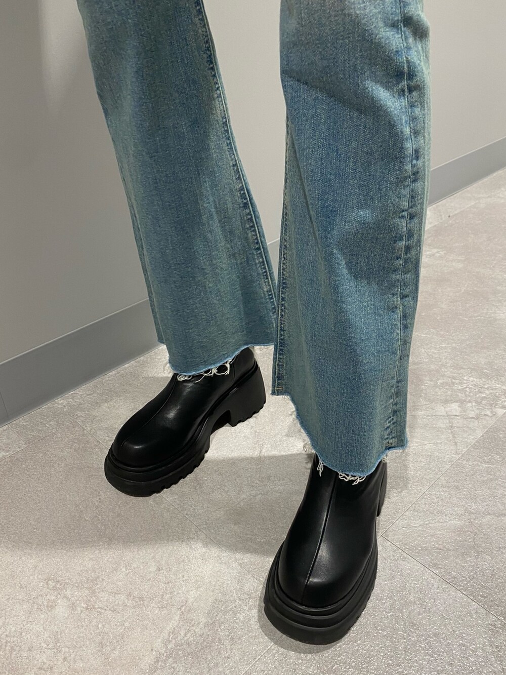 ブラック系のブルゾン、ブルー系のデニムパンツ、ホワイト系のニット/セーターを着用したレディースの冬コーディネートの7枚目の写真