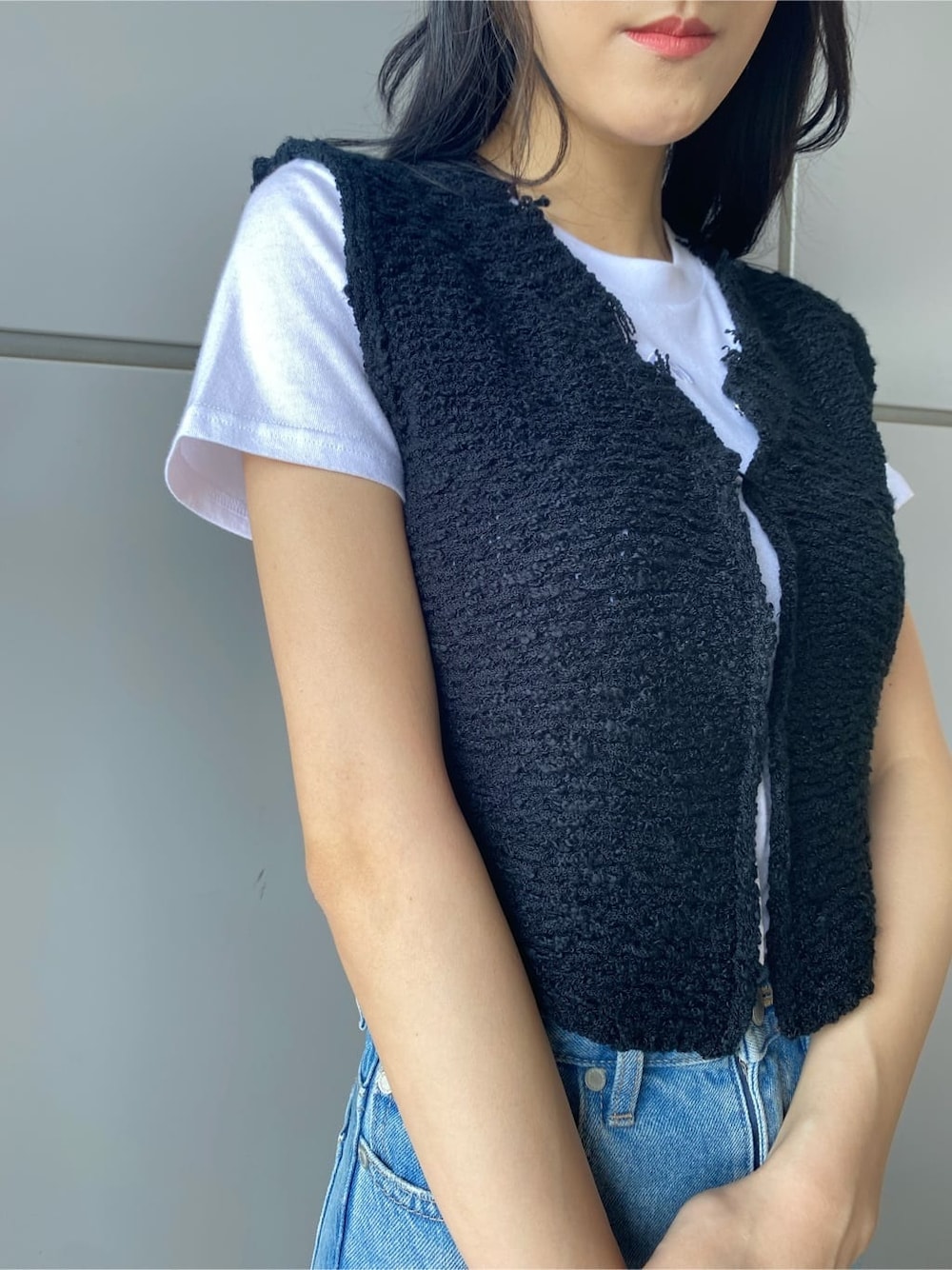 ブラック系のベスト、ブルー系のデニムパンツ、ホワイト系のTシャツ/カットソーを着用したレディースの夏コーディネートの5枚目の写真