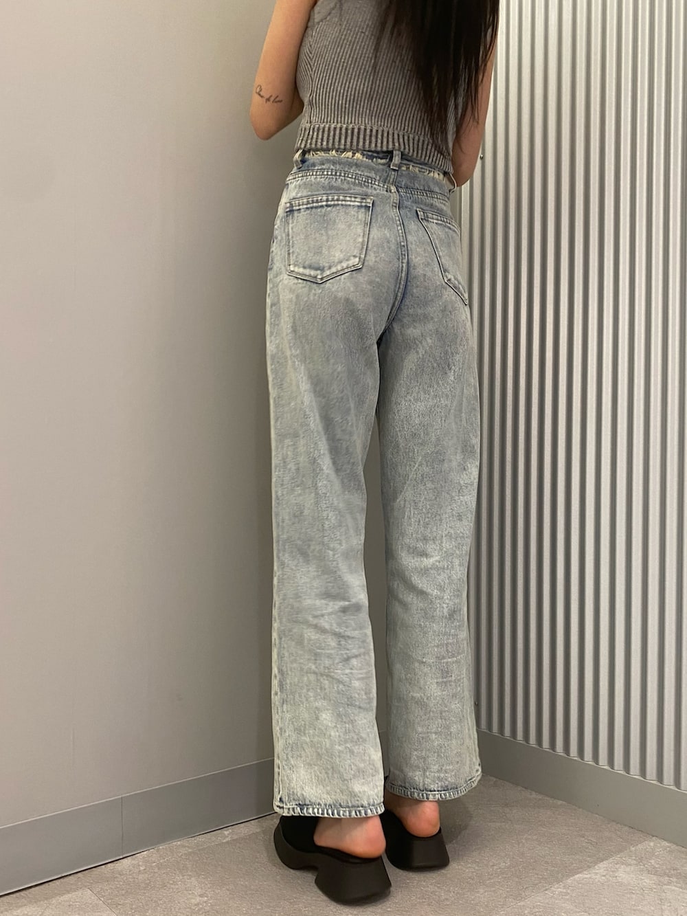 ブルー系のデニムパンツ、グレー系のニット/セーター、ブラック系のサンダルを着用したレディースの春コーディネートの8枚目の写真