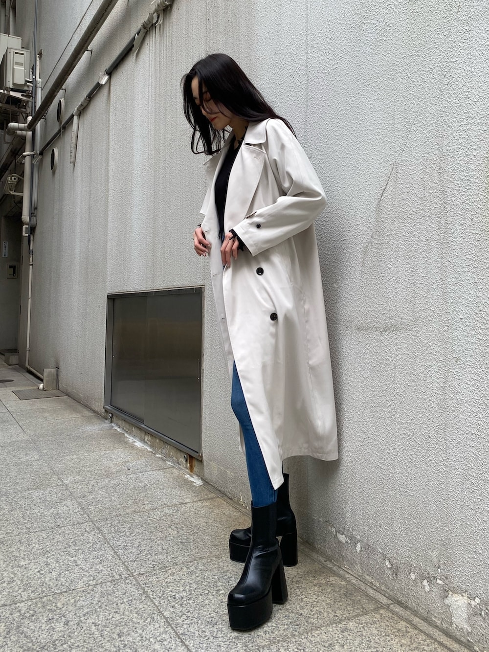 ブラック系のニット/セーター、ブルー系のデニムパンツ、ブラック系のブーツを着用したレディースの冬コーディネートの3枚目の写真